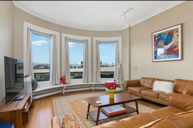 a living room with fireplace furniture and floor to ceiling window