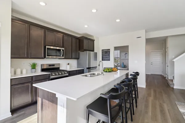 a kitchen with a dining table chairs and refrigerator