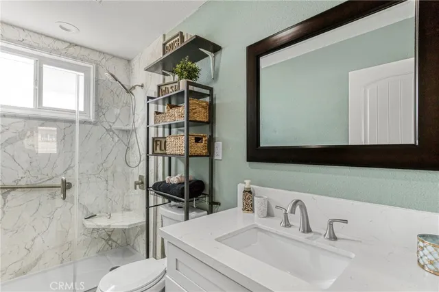 a bathroom with a sink a toilet and shower