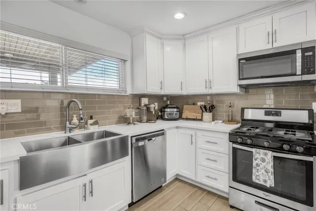 a kitchen with cabinets appliances a sink and a window