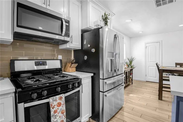a kitchen with stainless steel appliances granite countertop a stove a microwave and a refrigerator