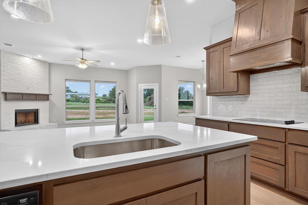 321 Skeen Peak Springtown, TX 76082 - Photo 9 of 37 Central kitchen island with an undermount sink and white solid surface countertop