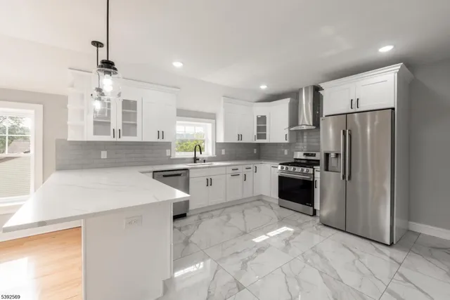 a kitchen with white cabinets and stainless steel appliances