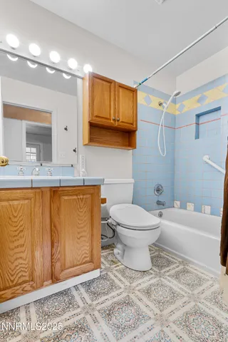 a bathroom with a granite countertop sink mirror vanity and toilet