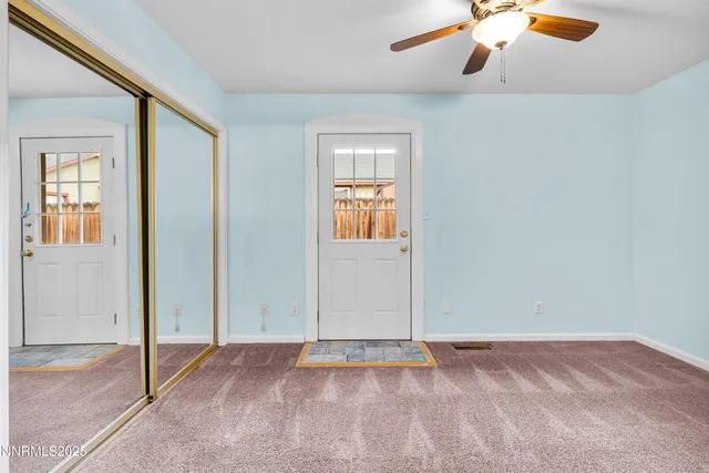 an empty room with closet and chandelier fan