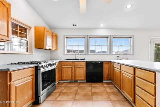 a large kitchen with stainless steel appliances granite countertop a stove sink and cabinets