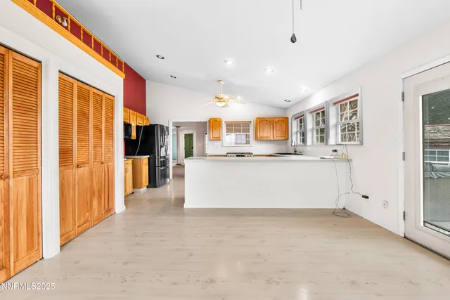 a view of kitchen with stainless steel appliances granite countertop a refrigerator and a stove