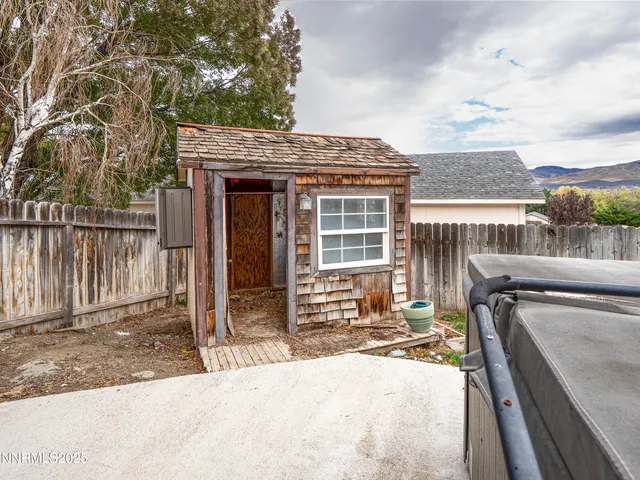 a roof deck with table and chairs and potted plants