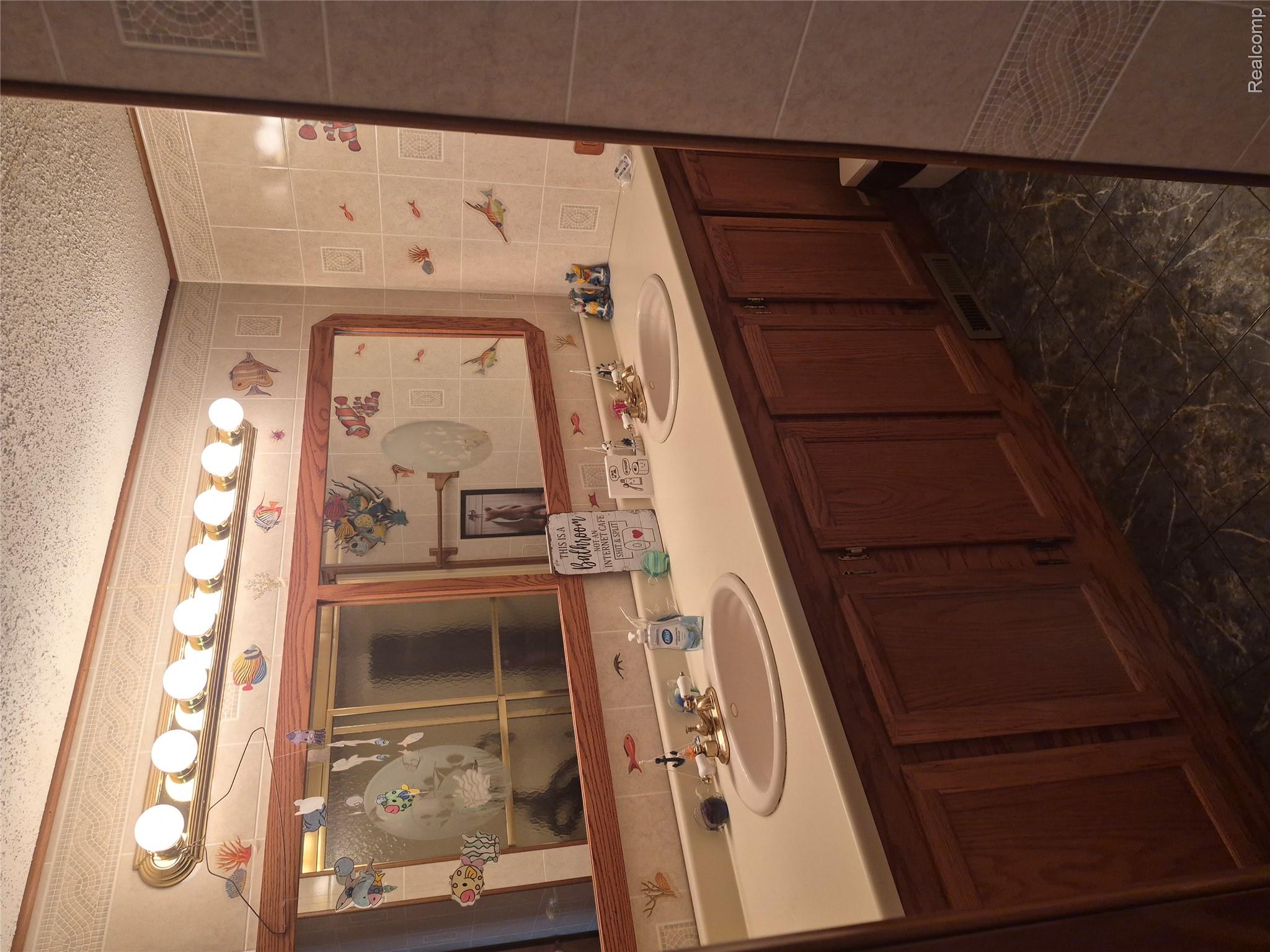 12849 South Delaney Road Perry, MI 48872 - Photo 17 of 34 Dual vanity with integrated sinks, wood-finish cabinetry, and a light-toned countertop