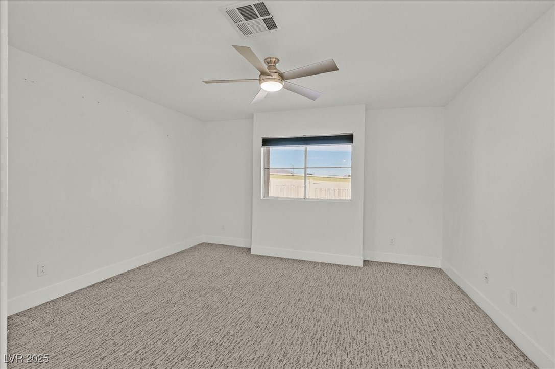 5421 Painted Mirage Road Las Vegas, NV 89149 - Photo 12 of 35 Empty room featuring light carpet, a ceiling fan, visible vents, and baseboards