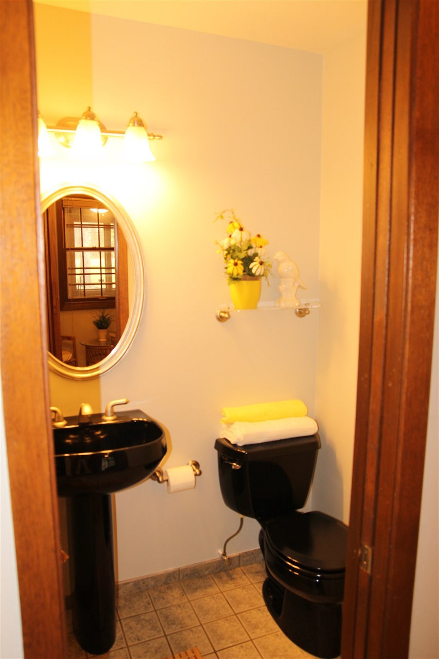 4972 Brookview Road Rockford, IL 61107 - Photo 12 of 22 a bathroom with a toilet mirror and vanity