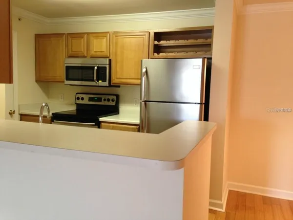 a kitchen with stainless steel appliances a refrigerator a stove a microwave and cabinets
