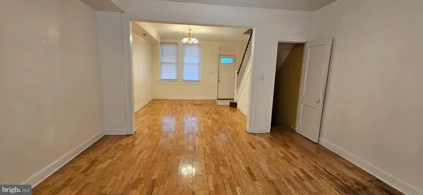 en empty room with wooden floor and fan