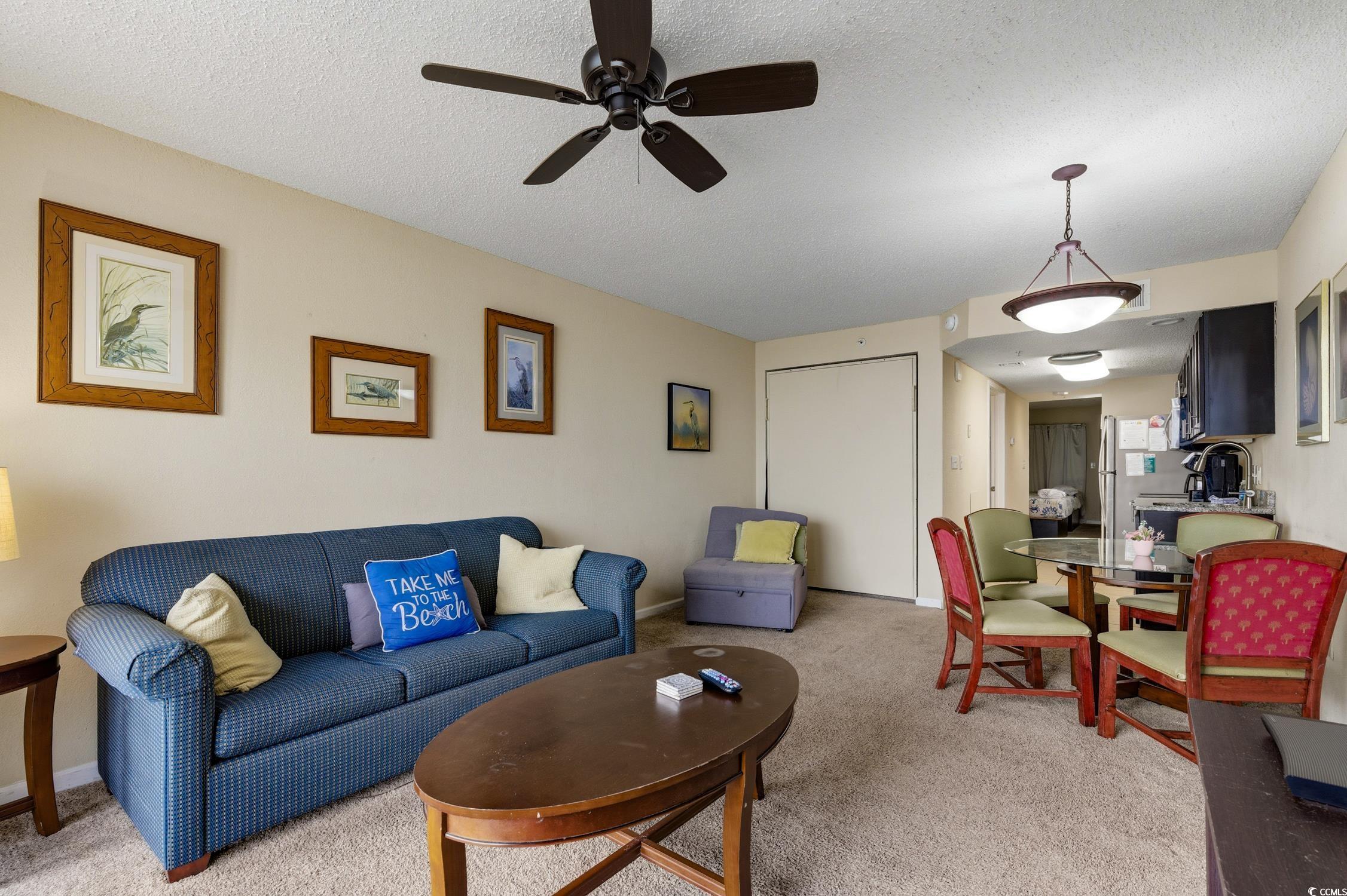 1702 North Ocean Boulevard, Unit 355 Myrtle Beach, SC 29577 - Photo 11 of 27 Living room featuring a textured ceiling, carpet floors, and ceiling fan