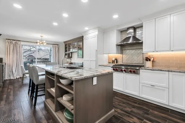 a kitchen with granite countertop a sink stove and cabinets