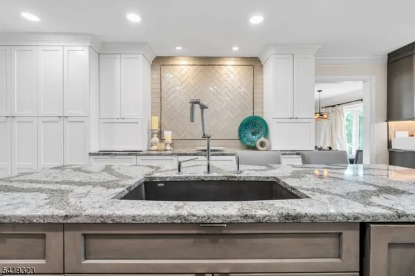 a kitchen with kitchen island granite countertop a sink and a window
