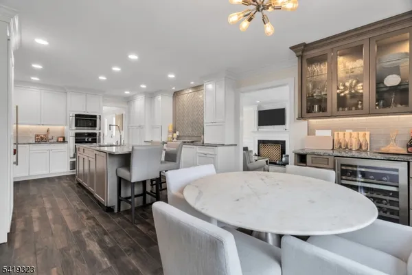 a large kitchen with kitchen island a stove a sink a dining table and chairs