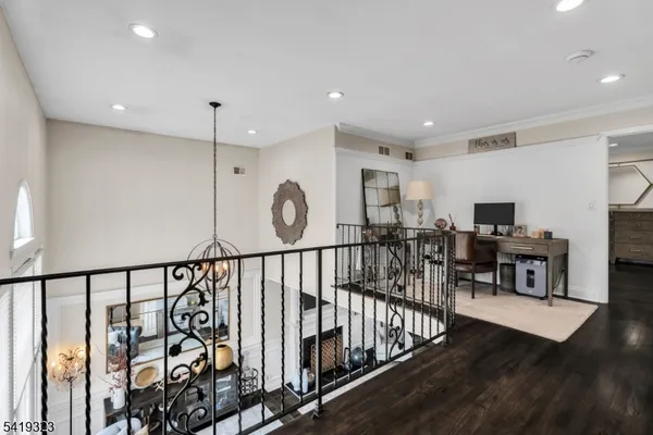 a view of a hallway with wooden floor and furniture