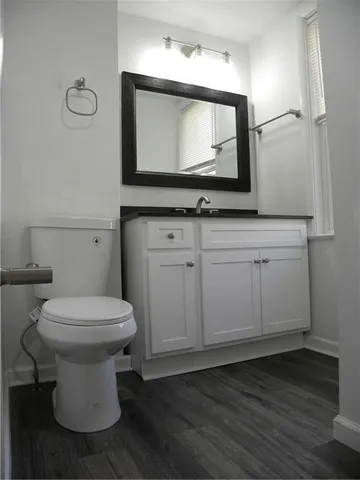 a bathroom with a toilet sink and mirror