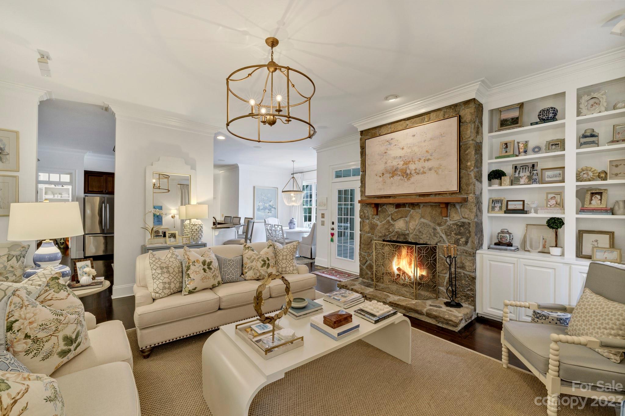 407 Bullfinch Bend Fort Mill, SC 29708 - Photo 17 of 46 a living room with furniture a fireplace and a chandelier