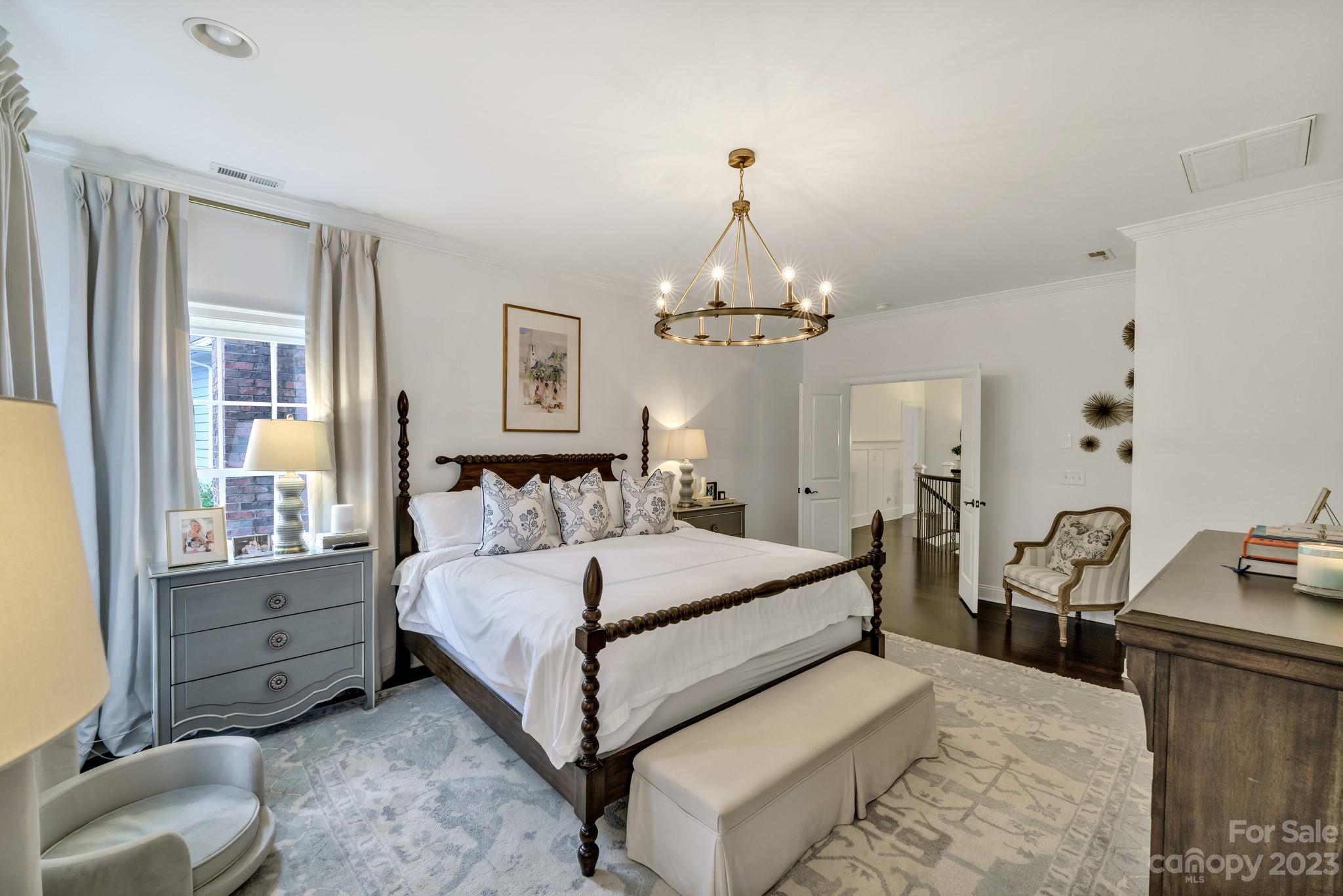 407 Bullfinch Bend Fort Mill, SC 29708 - Photo 32 of 46 a spacious bedroom with a bed and a chandelier