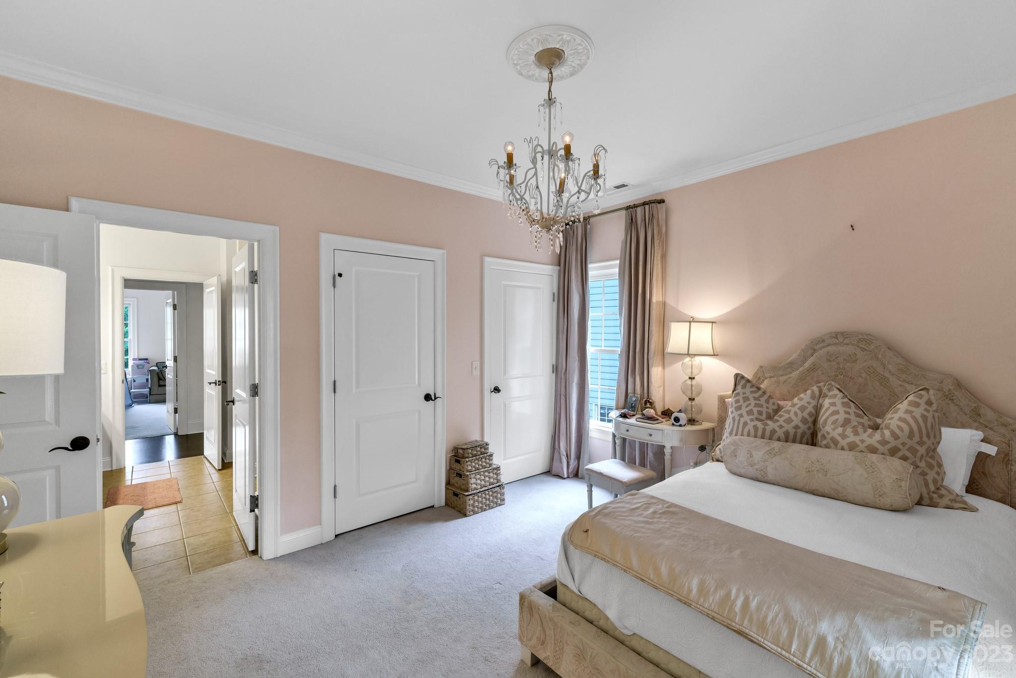 407 Bullfinch Bend Fort Mill, SC 29708 - Photo 38 of 46 a spacious bedroom with a bed and a chandelier