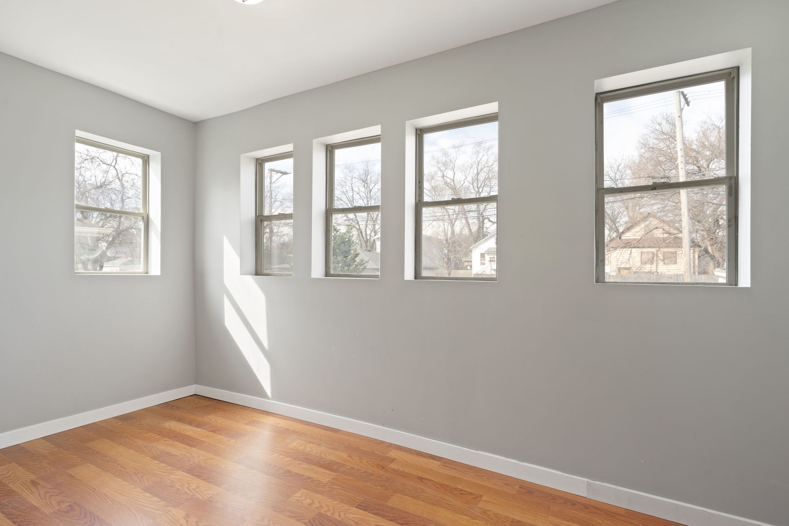 8048 South Avalon Avenue Chicago, IL 60619 - Photo 11 of 17 a view of an empty room with wooden floor and a window