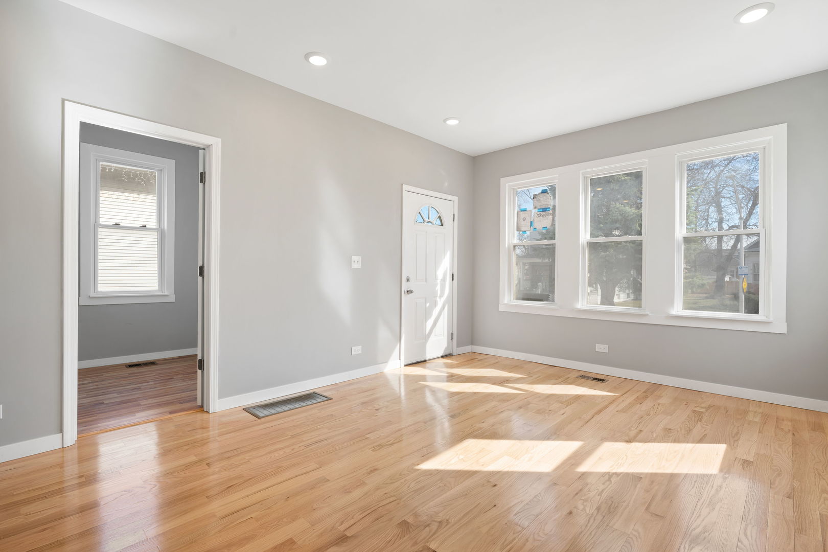 8048 South Avalon Avenue Chicago, IL 60619 - Photo 15 of 17 a view of an empty room with wooden floor and a window
