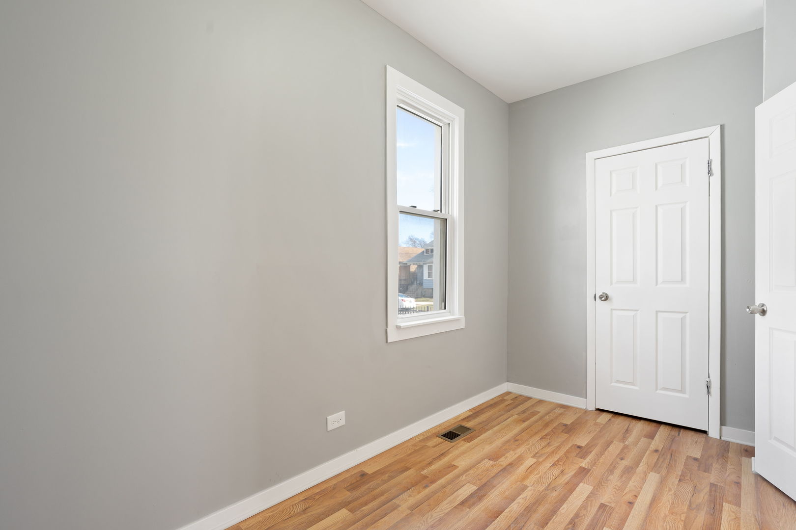 8048 South Avalon Avenue Chicago, IL 60619 - Photo 17 of 17 an empty room with wooden floor and windows