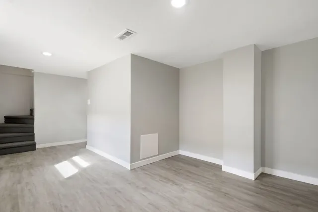 a view of empty room with wooden floor