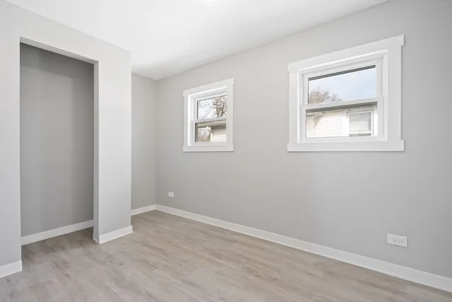 an empty room with windows and closet