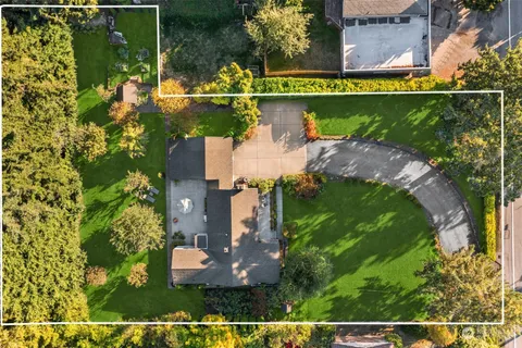 an aerial view of a house with a garden and lake view