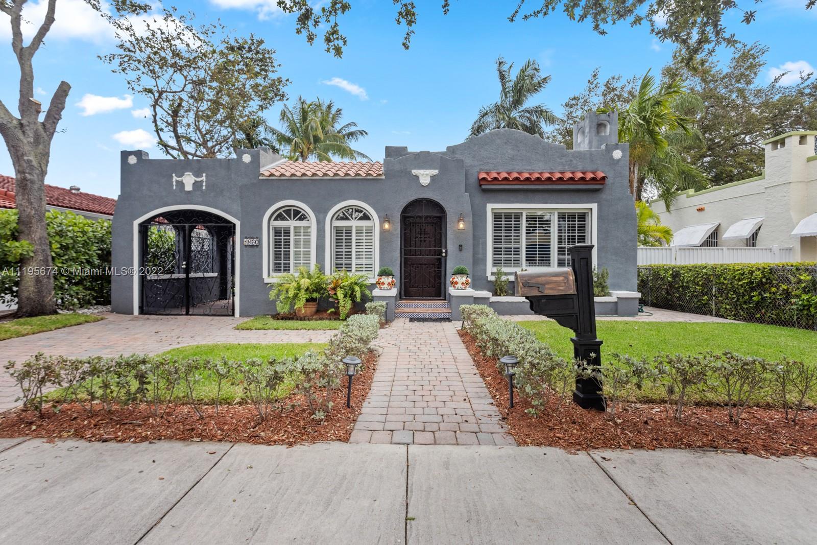 a front view of a house with a yard and potted plants