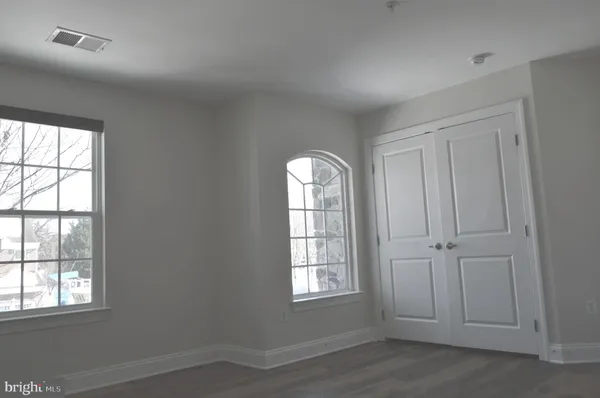 an empty room with windows and closet