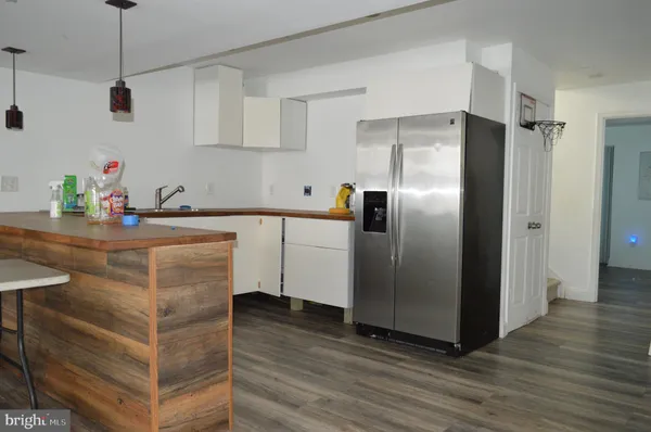 a kitchen with stainless steel appliances granite countertop a refrigerator a sink a stove and a wooden floors