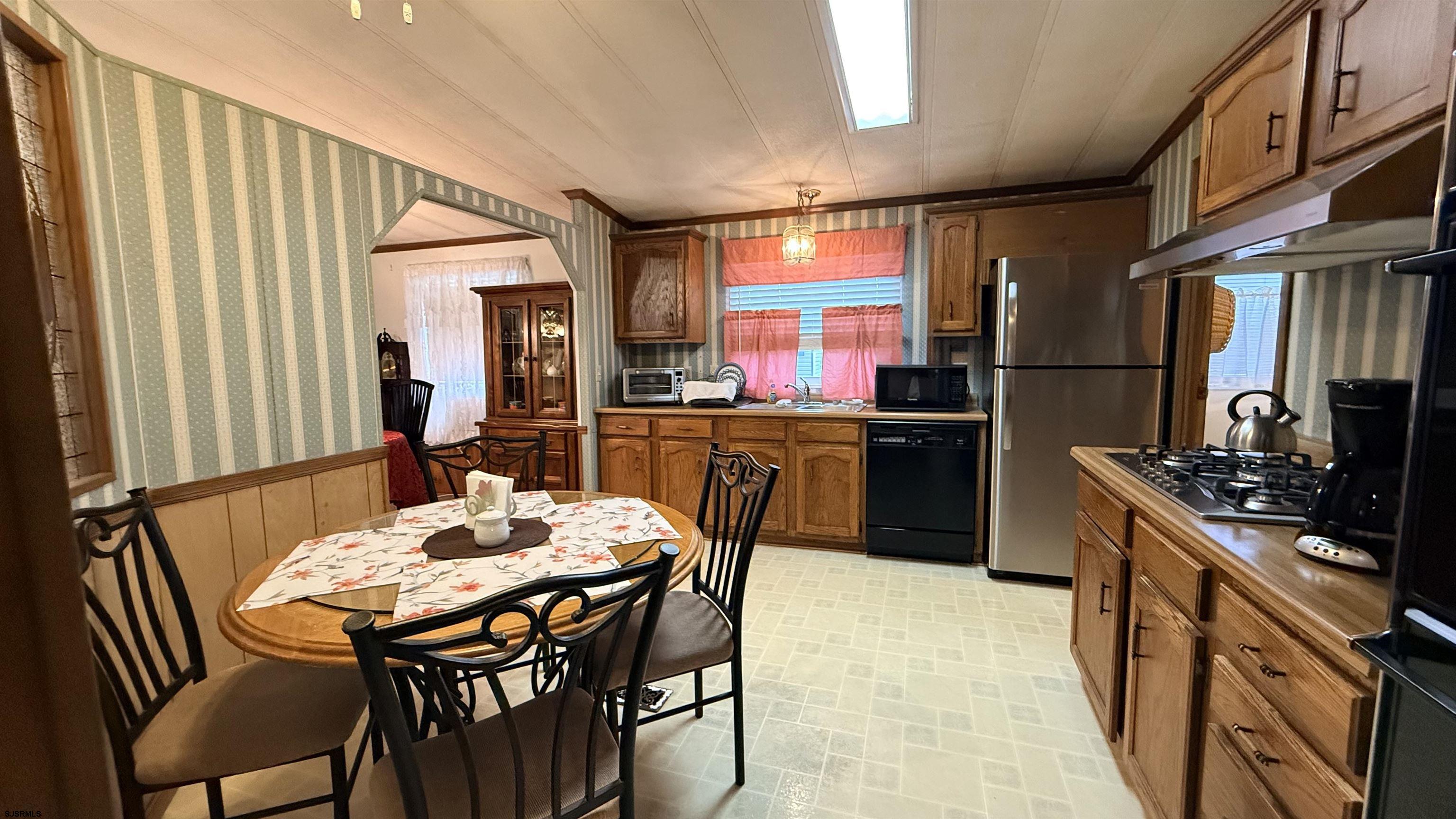 581 Miles Standish Lane Buena, NJ 08310 - Photo 11 of 32 a kitchen with stainless steel appliances a dining table and chairs
