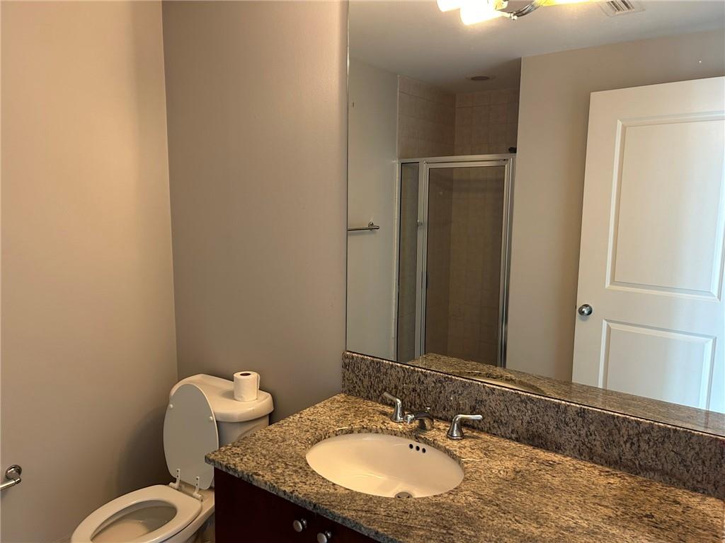 3338 Peachtree Road Northeast, Unit 2102 Atlanta, GA 30326 - Photo 11 of 14 a bathroom with a granite countertop sink and a mirror