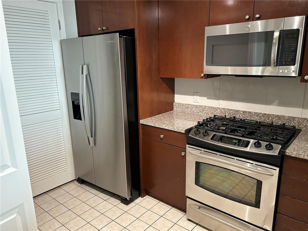 3338 Peachtree Road Northeast, Unit 2102 Atlanta, GA 30326 - Photo 5 of 14 a kitchen with stainless steel appliances wooden cabinets and stove