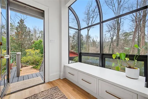 a kitchen with large window and wooden floor