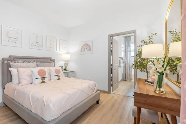 a bedroom with a bed a table and painting on the wall