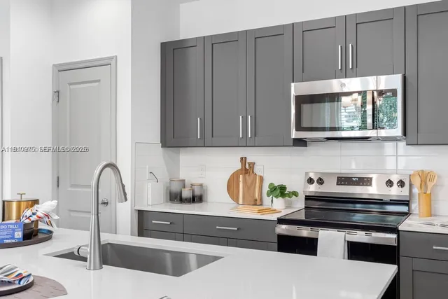 a kitchen with stainless steel appliances granite countertop a sink stove and cabinets