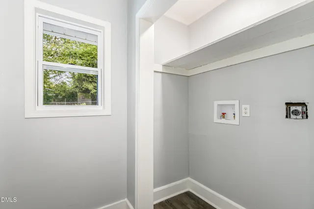 a large kitchen with white cabinets and wooden floor