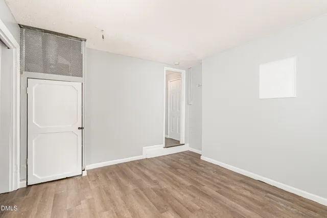 a view of a room with wooden floor