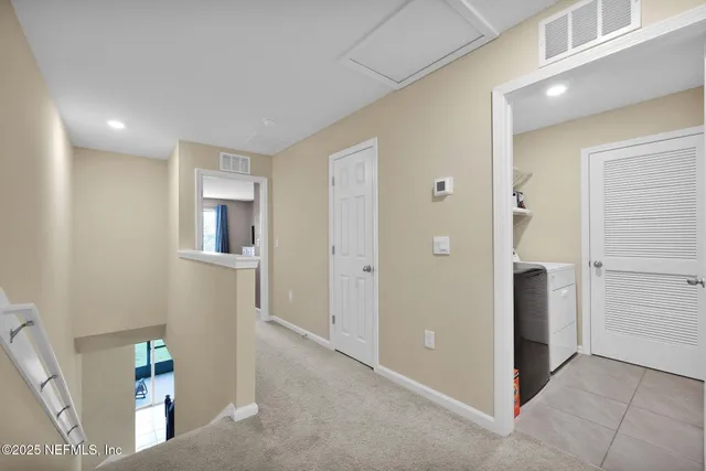 a view of a hallway with bathroom and wooden floor