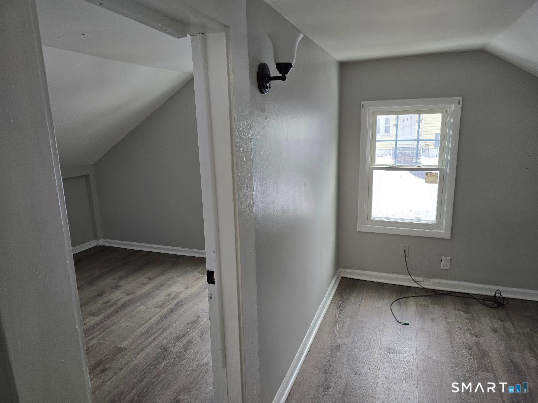 116 Rosette Street Waterbury, CT 06708 - Photo 6 of 7 a view of an empty room with wooden floor and a window
