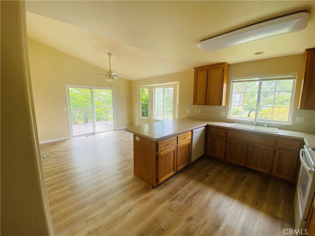 16506 Ridgecrest Court Hidden Valley Lake, CA 95467 - Photo 6 of 25 a large white kitchen with wooden floors and stainless steel appliances