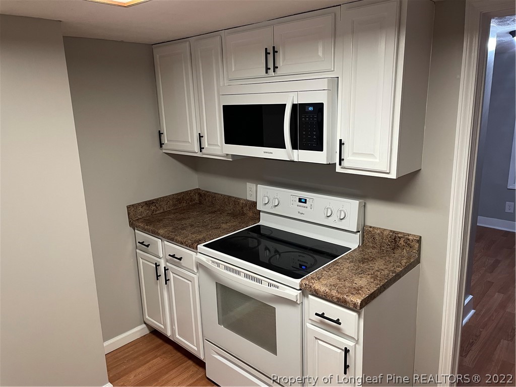1215-1219 Camden Road Fayetteville, NC 28306 - Photo 14 of 25 a kitchen with granite countertop white cabinets and stainless steel appliances