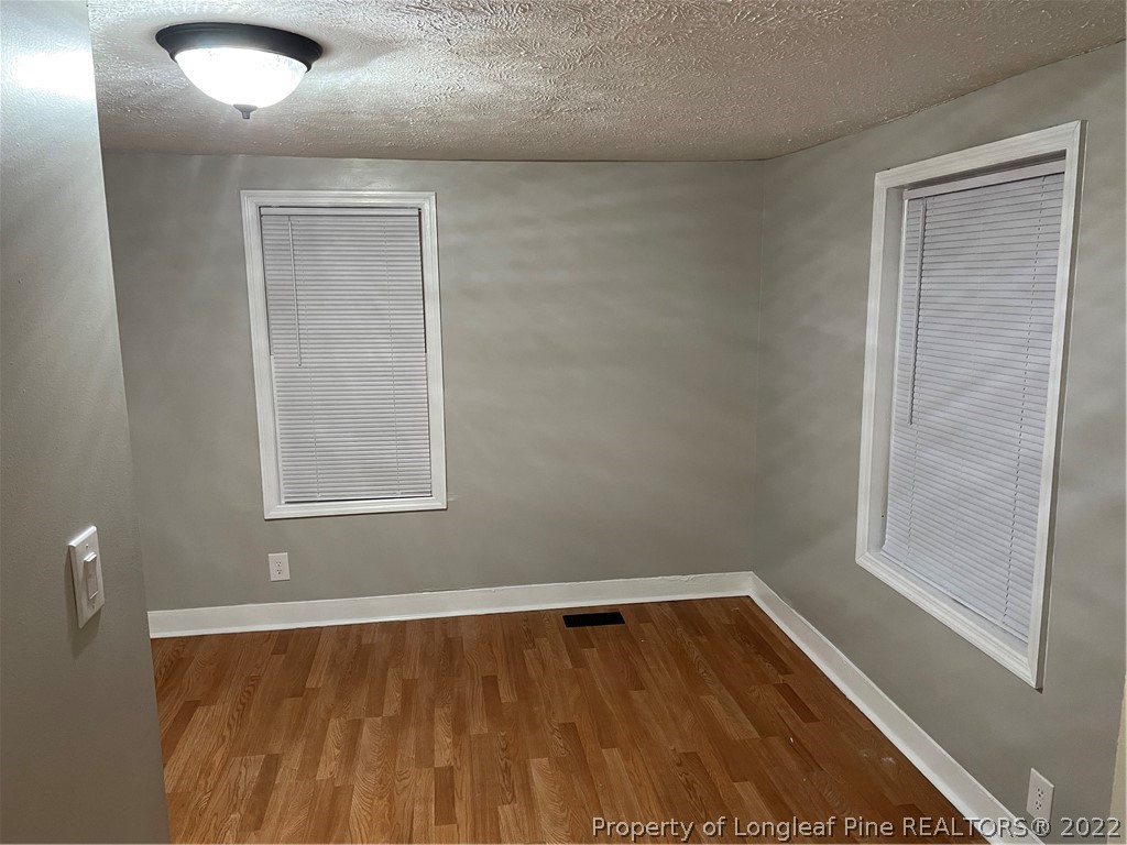 1215-1219 Camden Road Fayetteville, NC 28306 - Photo 17 of 25 a view of an empty room with wooden floor and a window