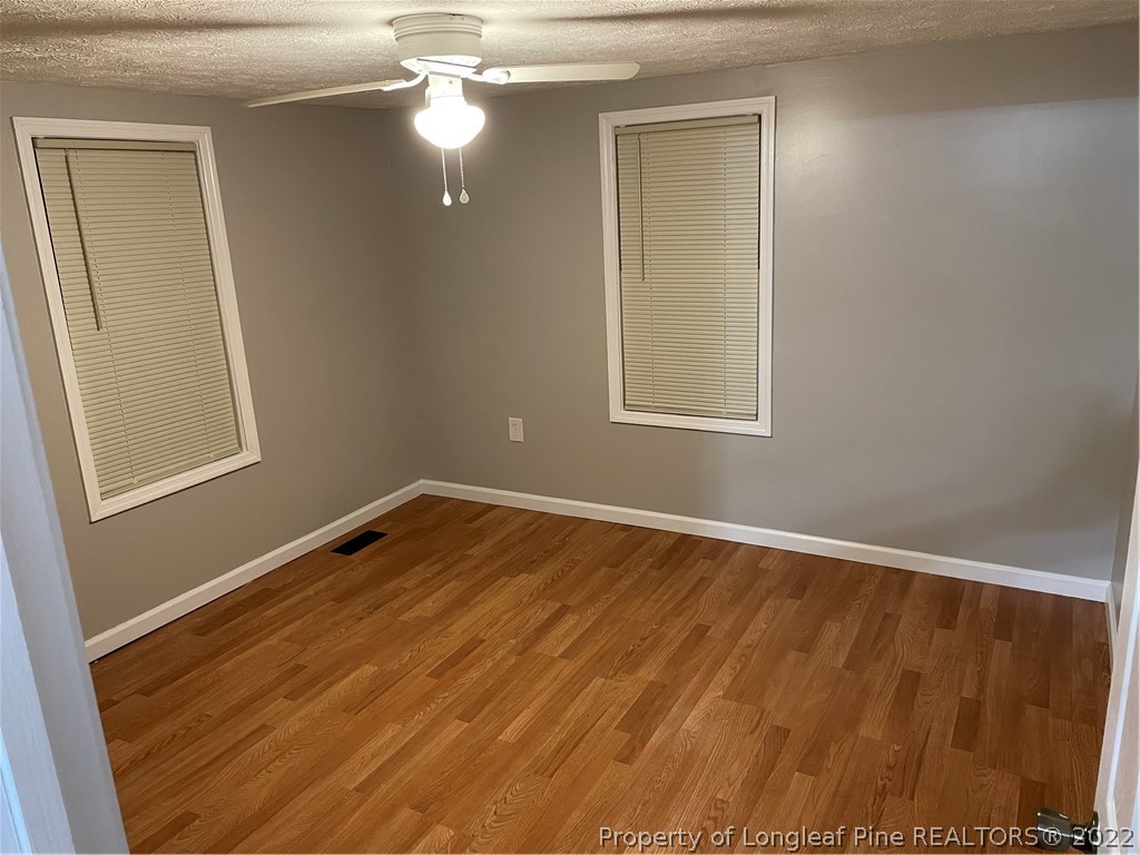 1215-1219 Camden Road Fayetteville, NC 28306 - Photo 25 of 25 an empty room with wooden floor and windows