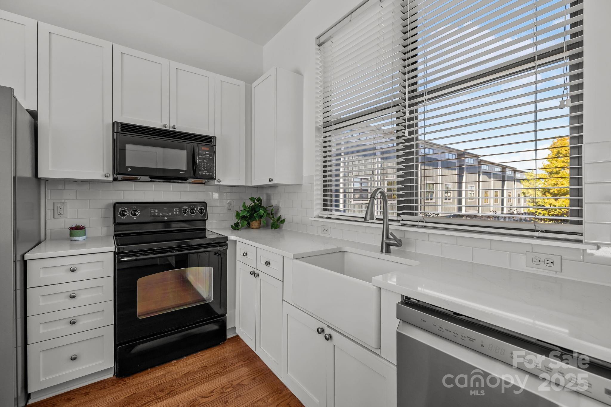 927 East 8th Street Charlotte, NC 28204 - Photo 5 of 35 a kitchen with cabinets stainless steel appliances a sink and a window